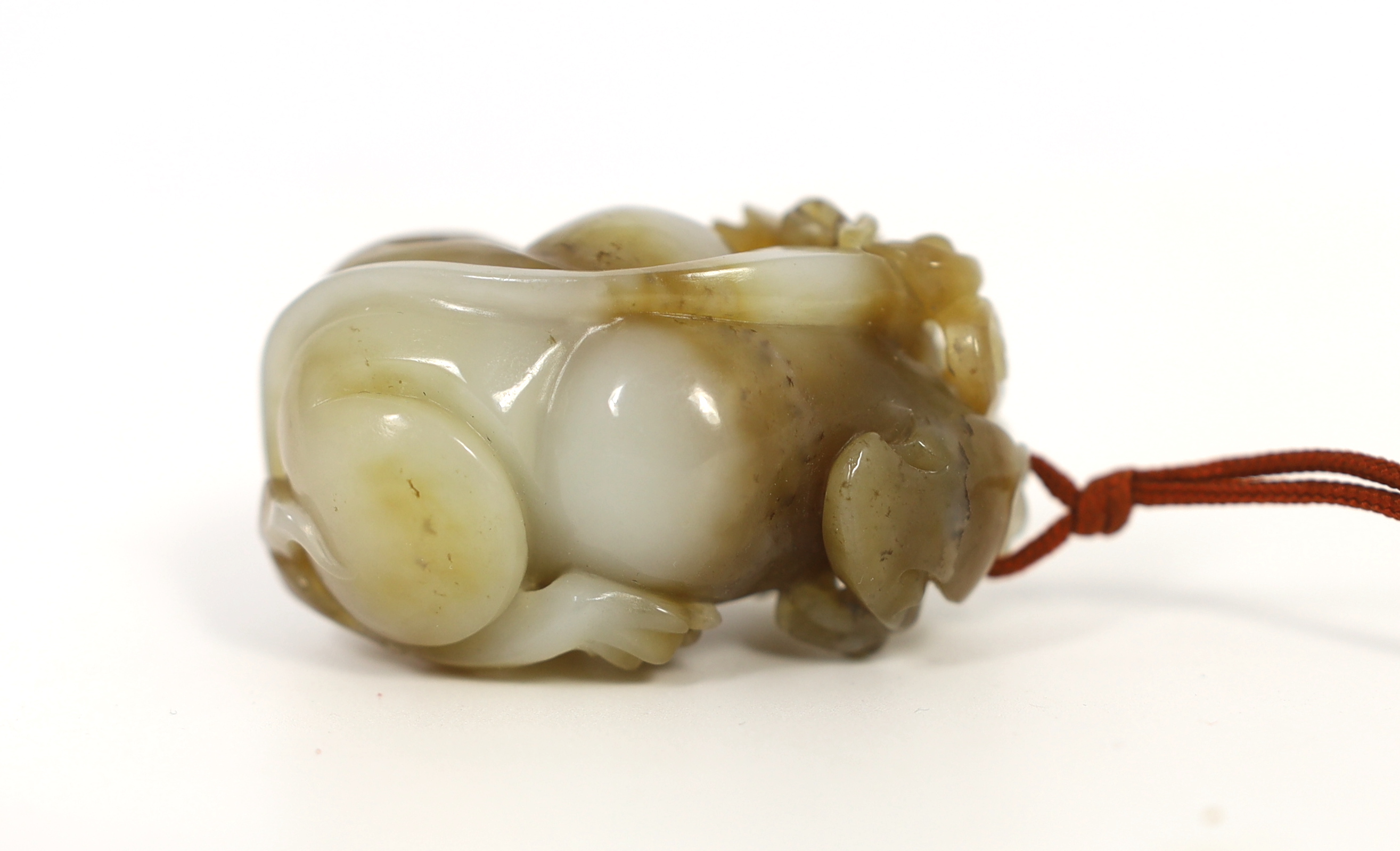 A Chinese white and brown jade lion-dog carving